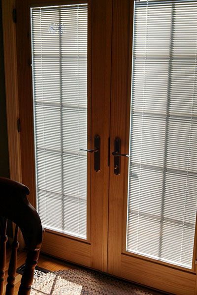 A pair of sliding glass doors with blinds in a living room.