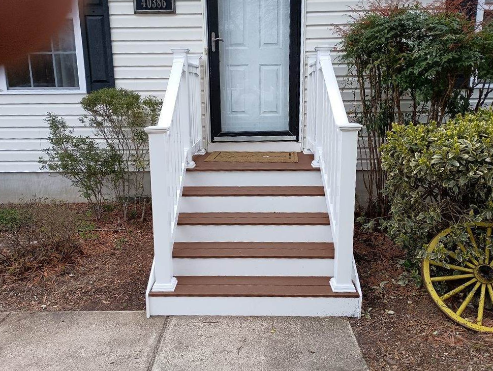 A white house with a wooden porch and stairs
