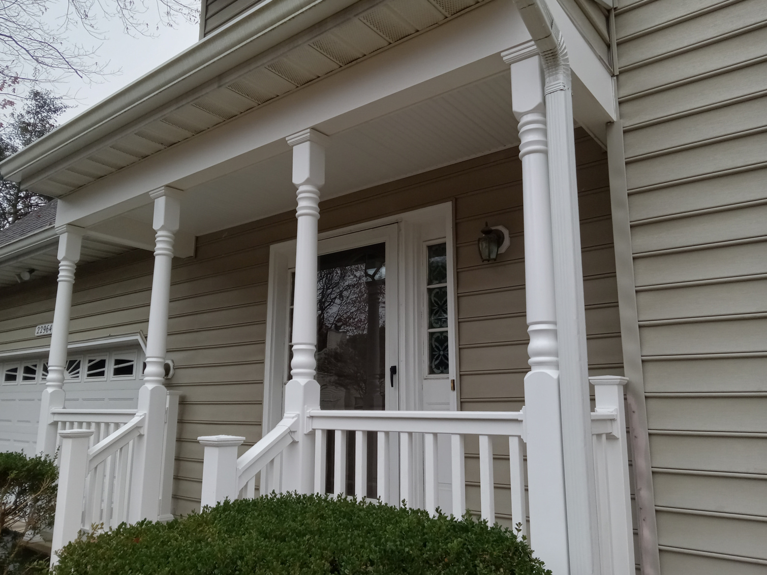 A house with a porch and a garage door