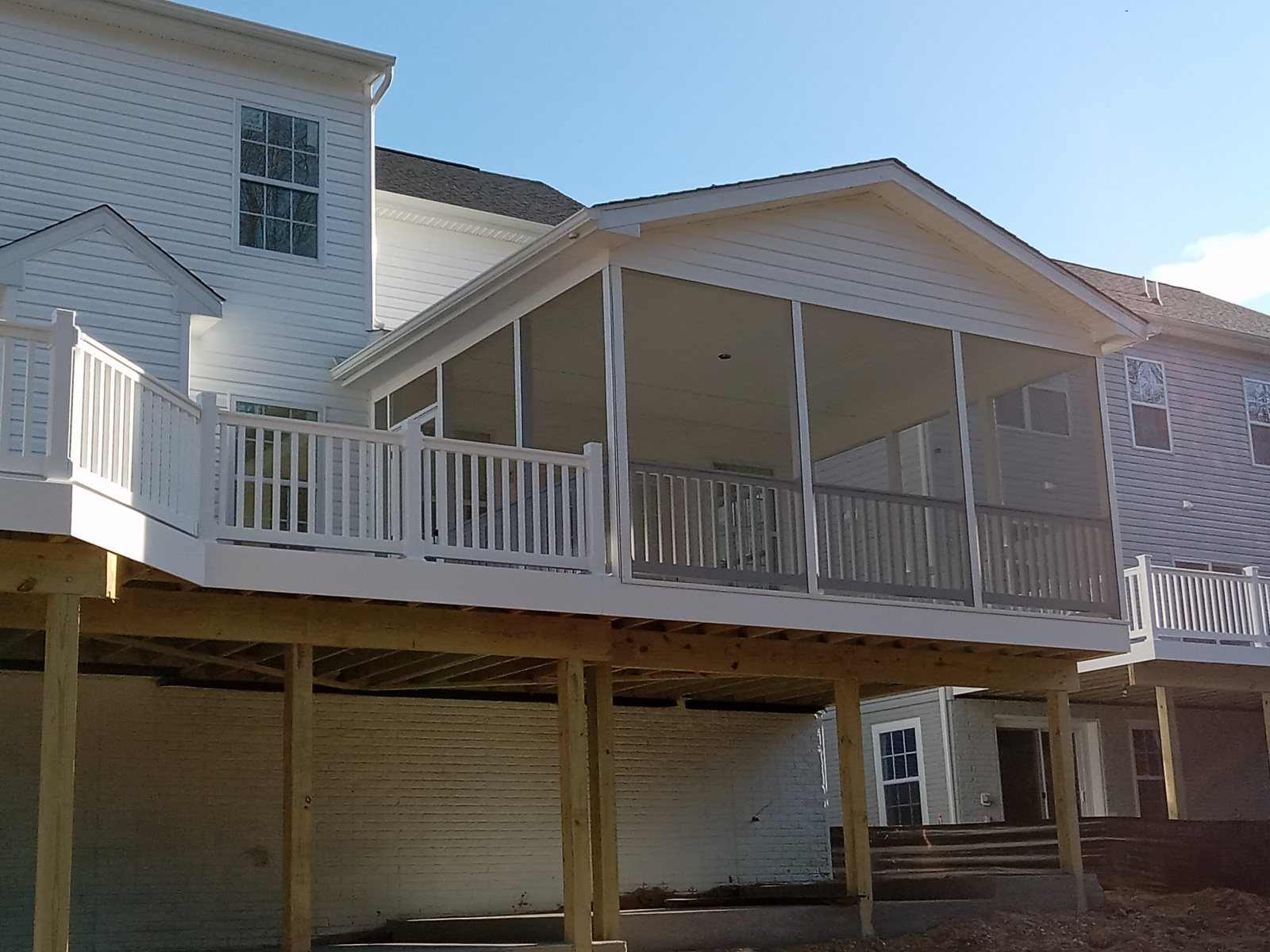 A house with a screened in porch on the back of it