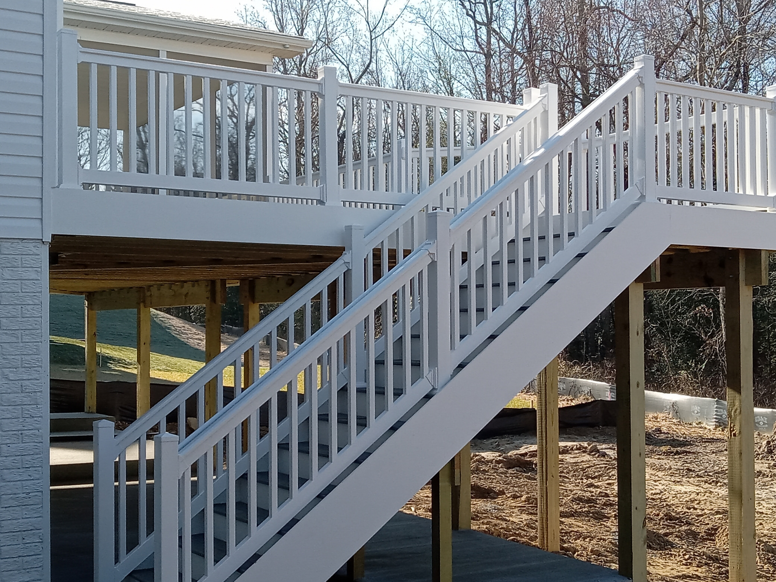 A white deck with stairs leading up to it
