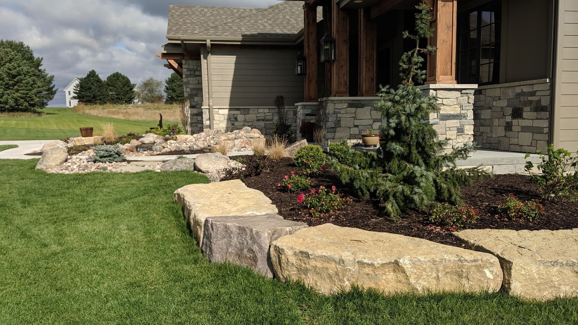 Exterior view of a house with a stone and rock garden in the front yard.