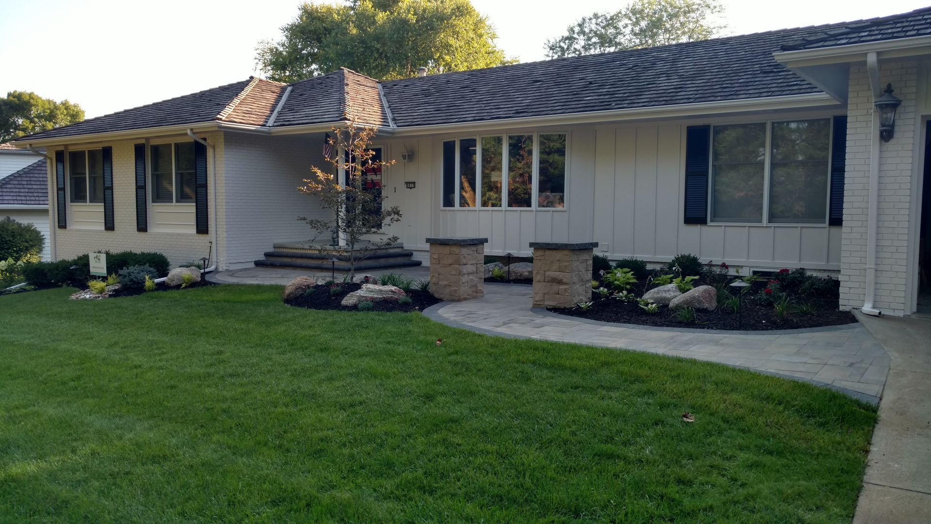 Gray house with landscaped yard and stone walkway.