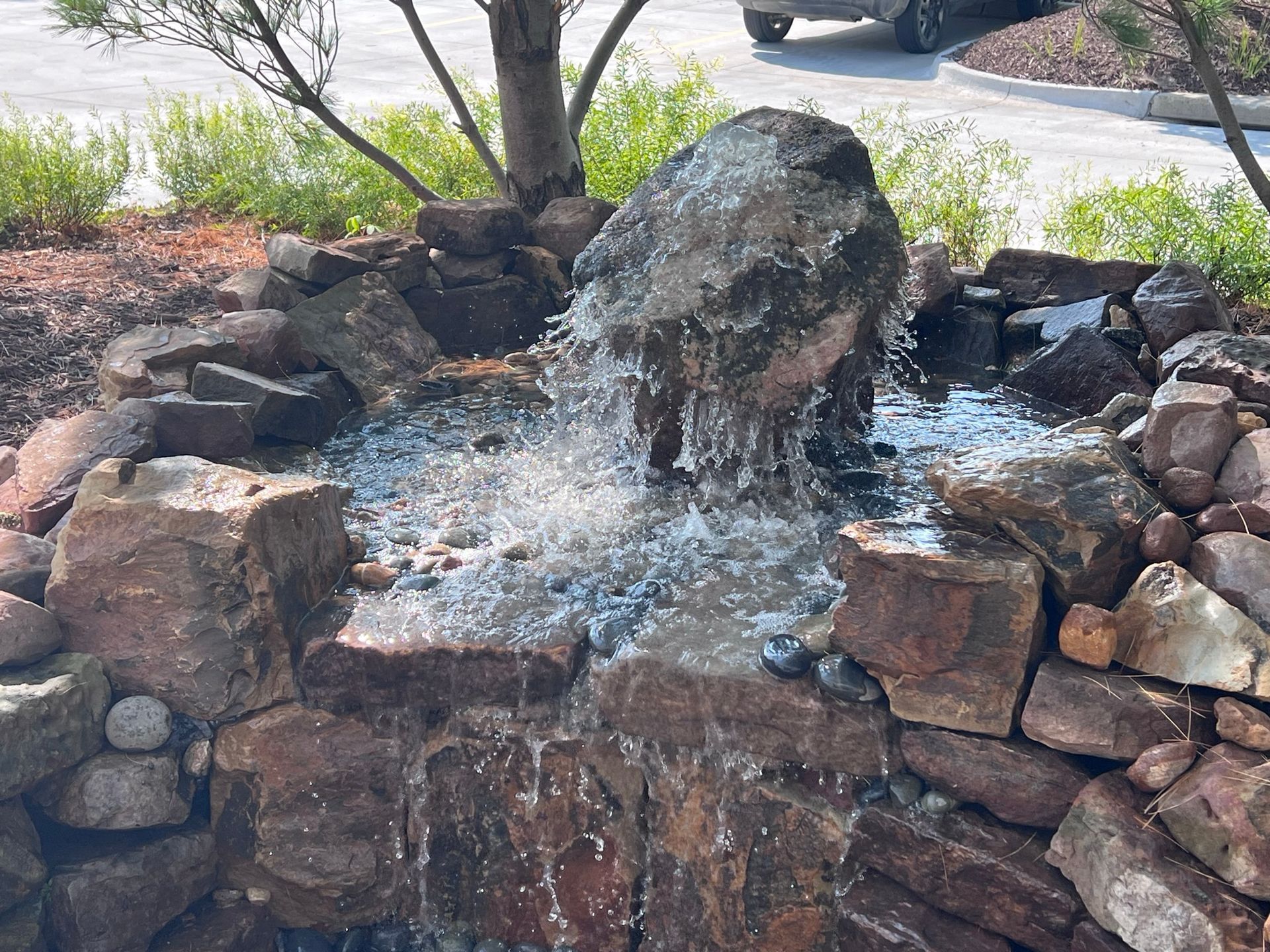 Water feature with rocks and waterfall, outdoors.