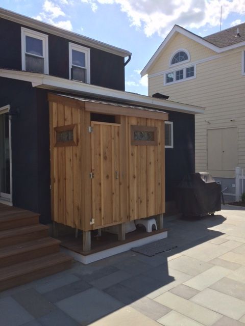 a house with a wooden shed in front of it