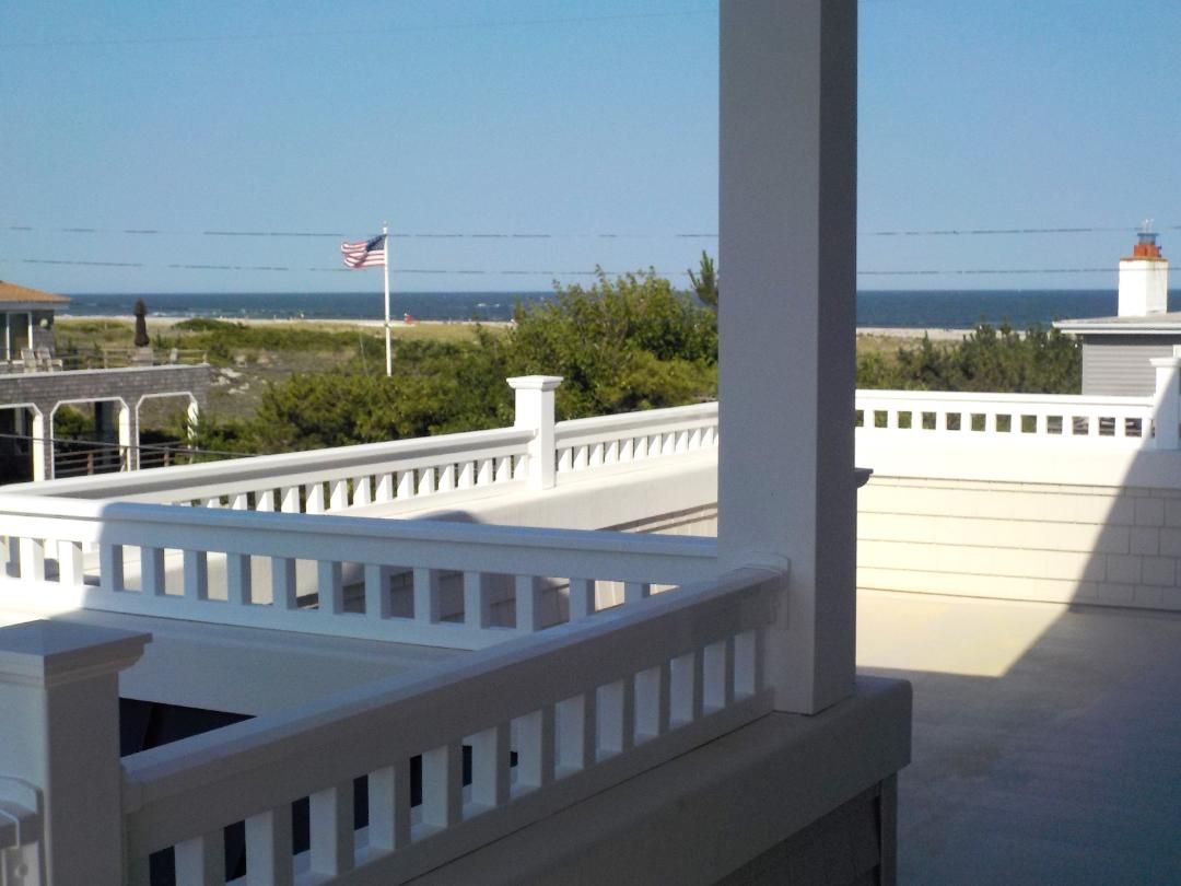 a view of the ocean from a balcony with a white railing