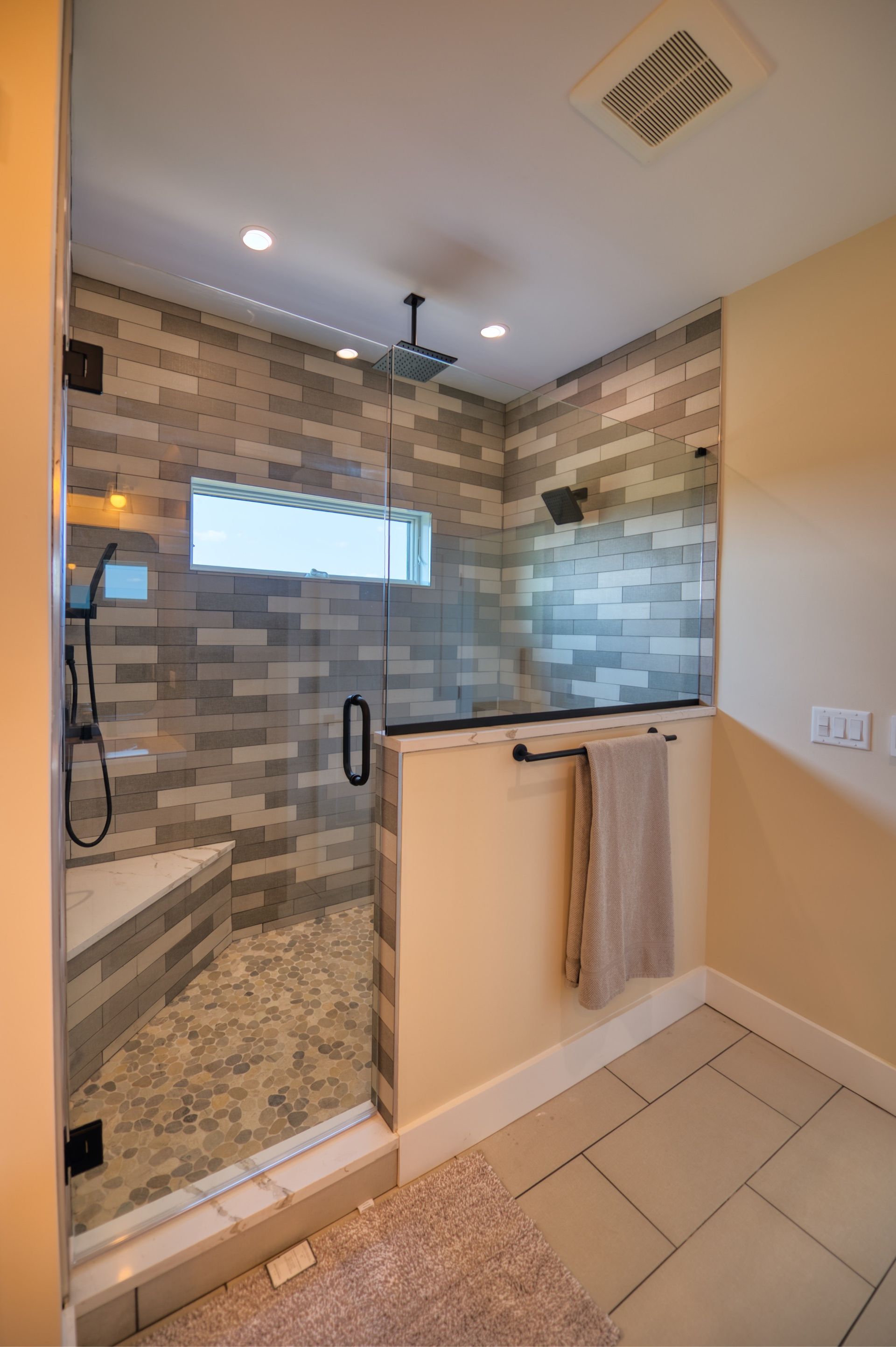 a bathroom with a walk in shower and a window .