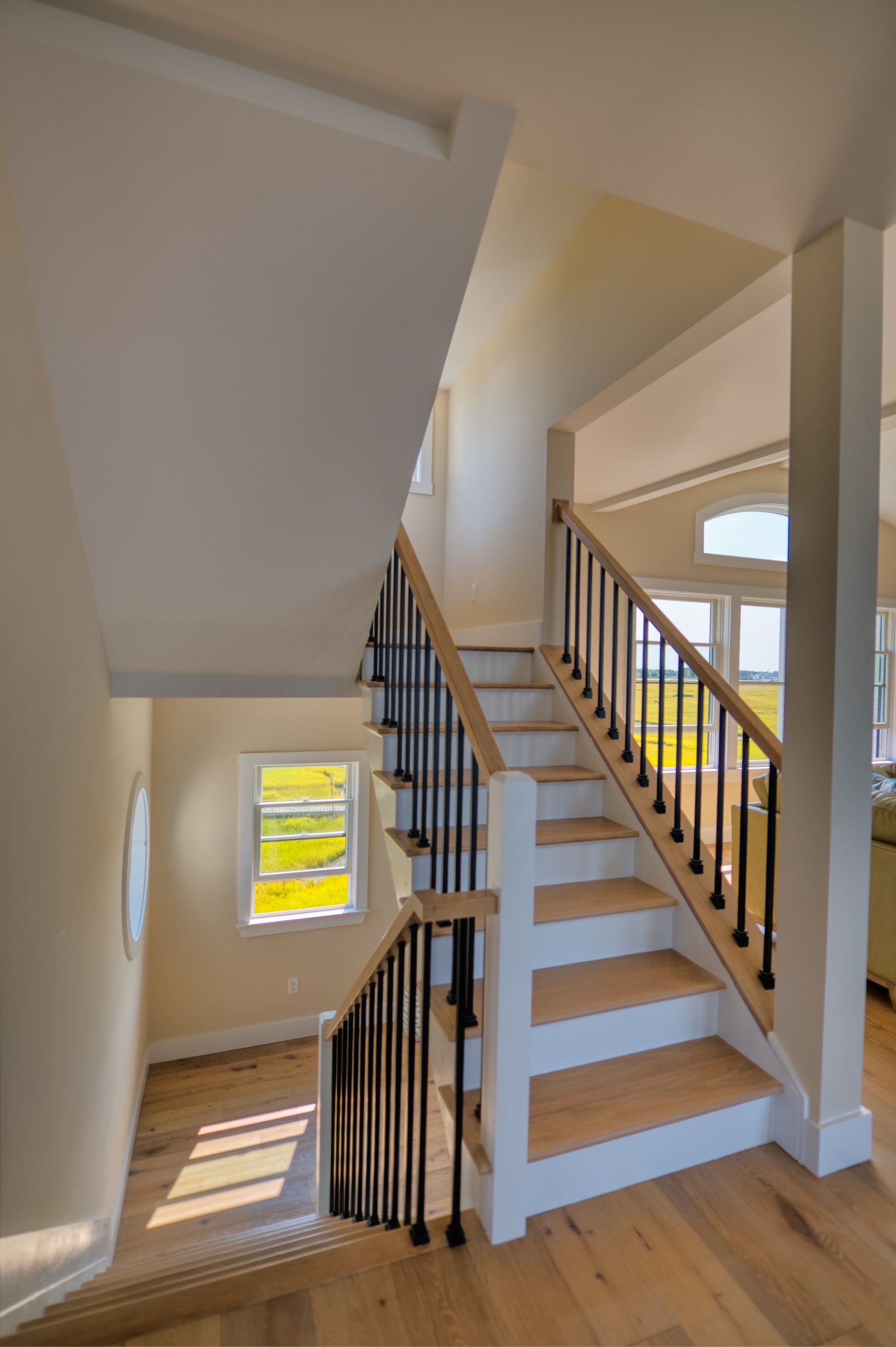 a staircase in a house with wooden steps and a black railing .
