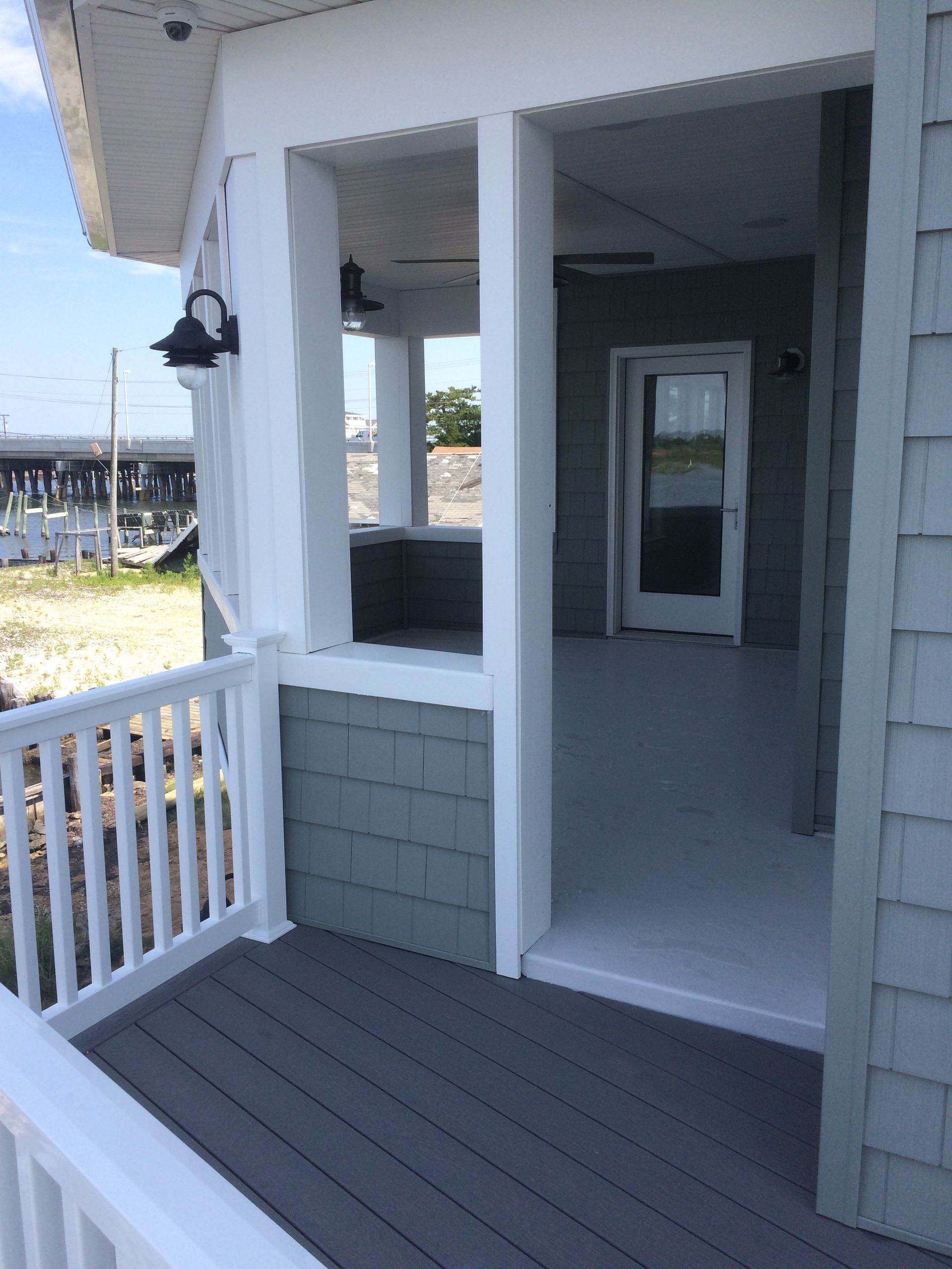 a porch with a white railing and a glass door