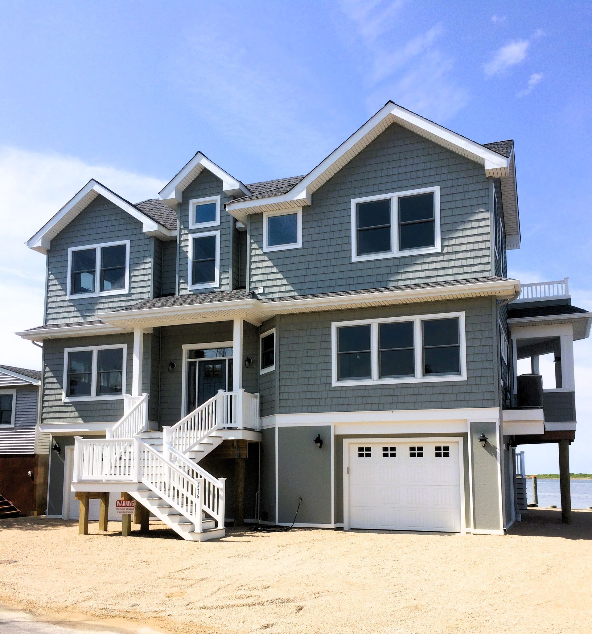 a large house with a white garage door and stairs