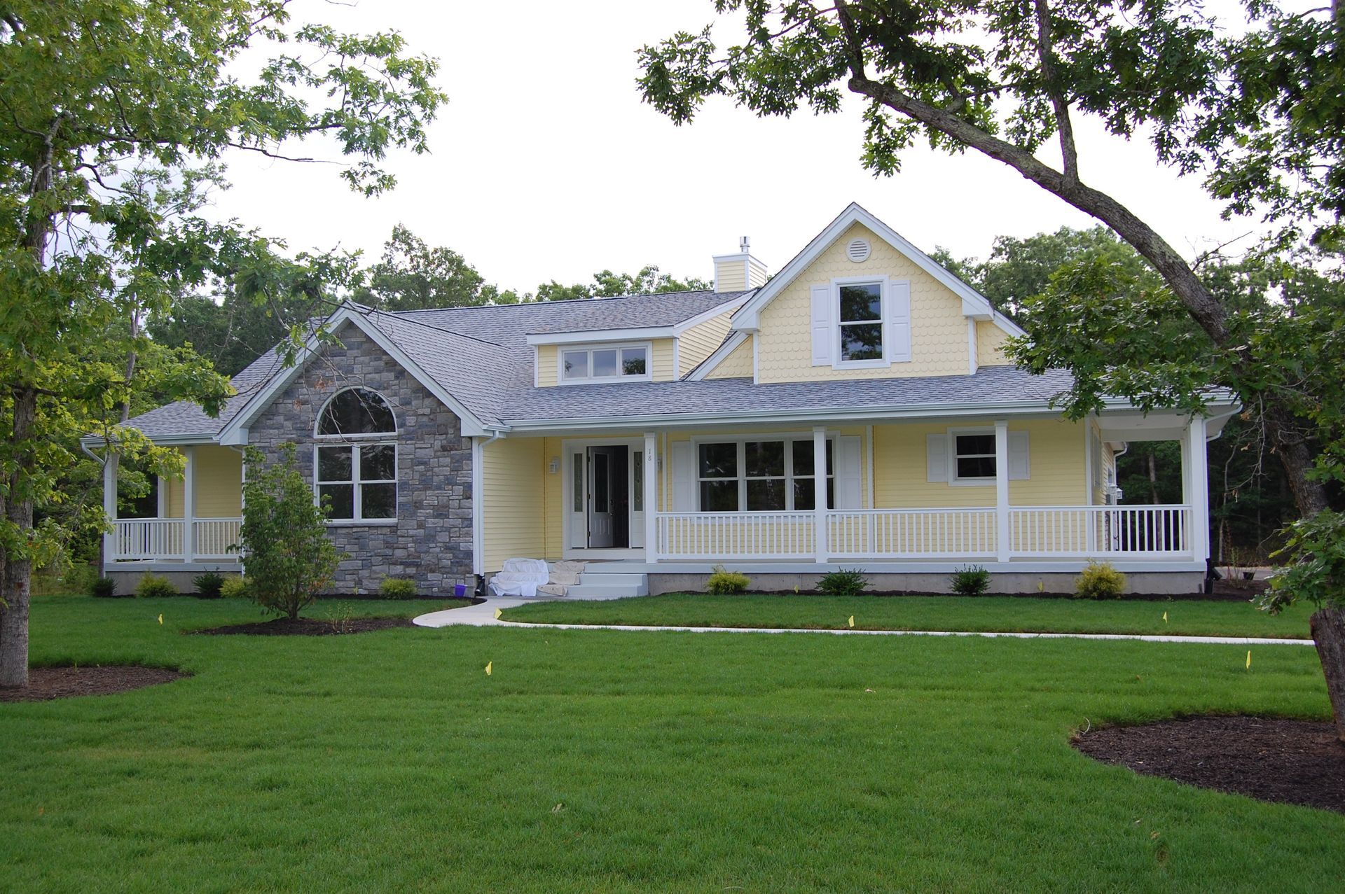 a large yellow house with a large porch