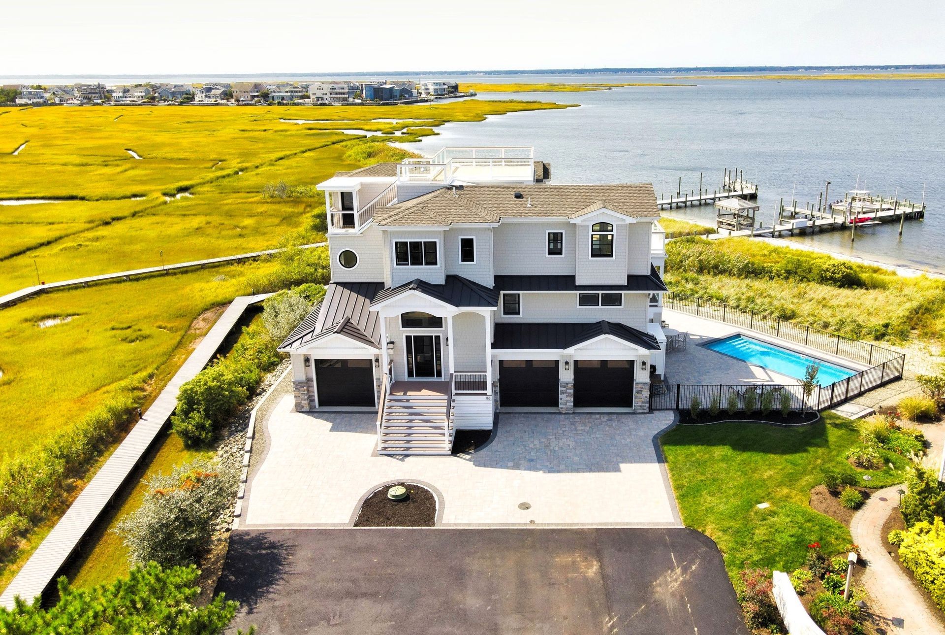 an aerial view of a large house next to a body of water
