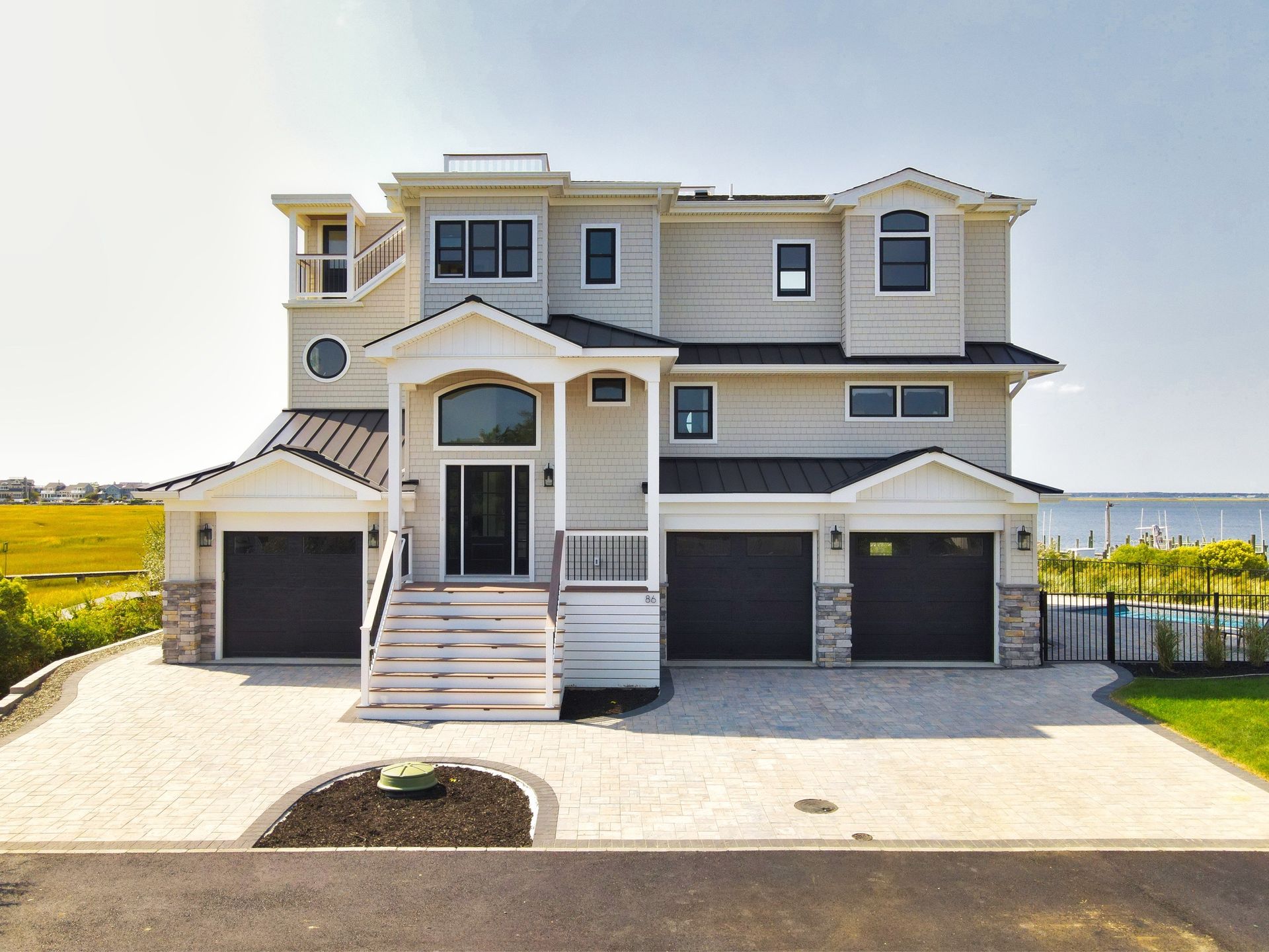 a large white house with black garage doors