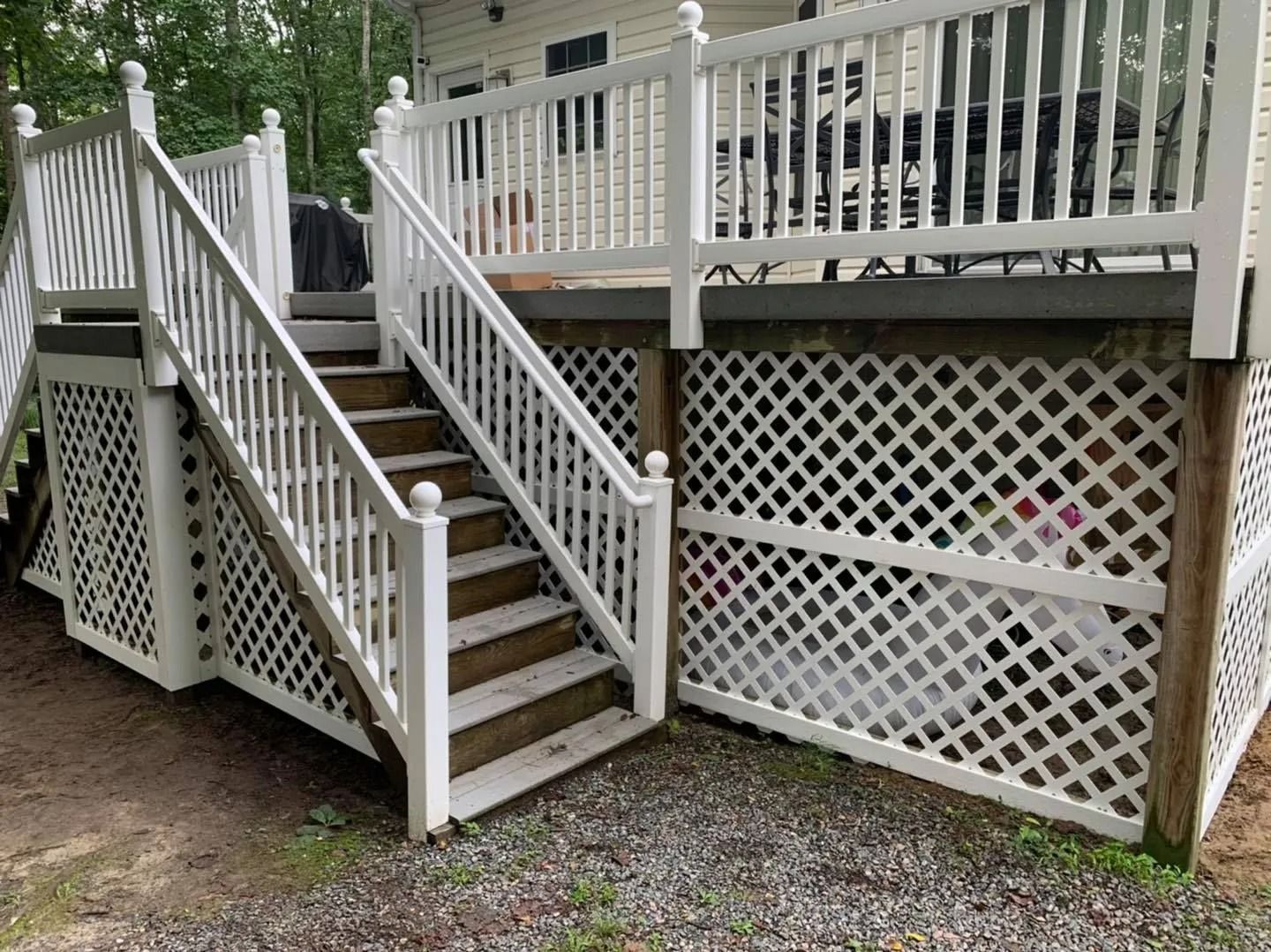 White deck with latticework skirting and stairs.