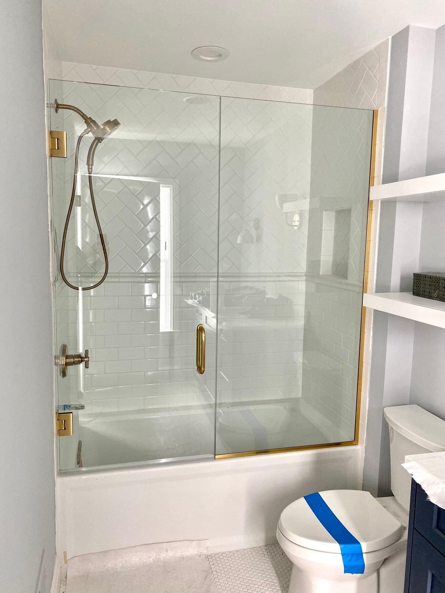 Glass shower door with gold trim