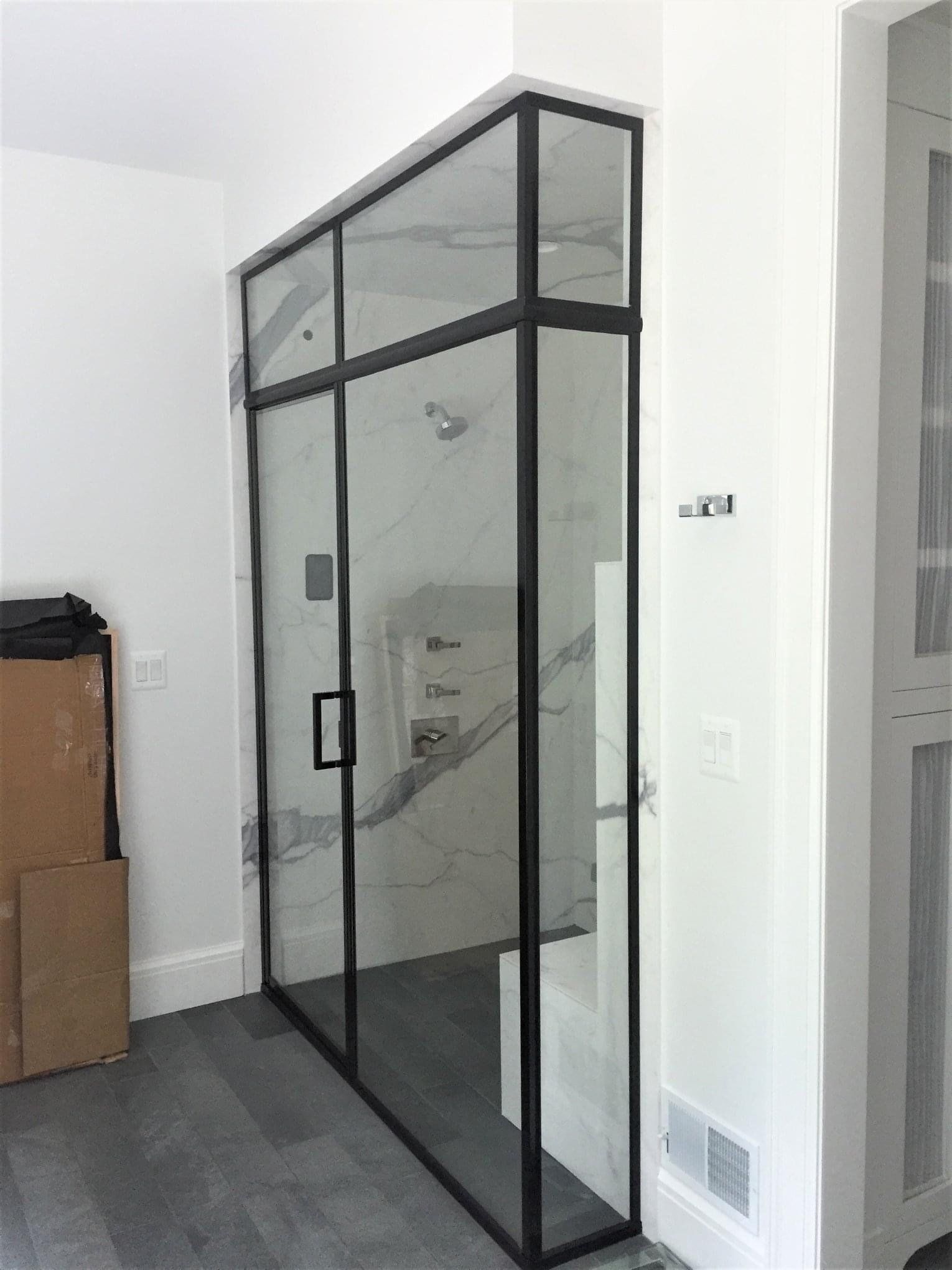 Glass shower door with black metal frame