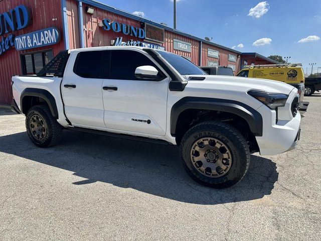 White pickup truck parked outside a brick auto shop on a sunny day