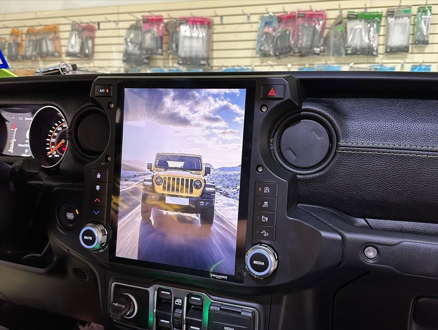 Jeep dashboard with a center touchscreen showing an off-road Jeep driving on a snowy trail.