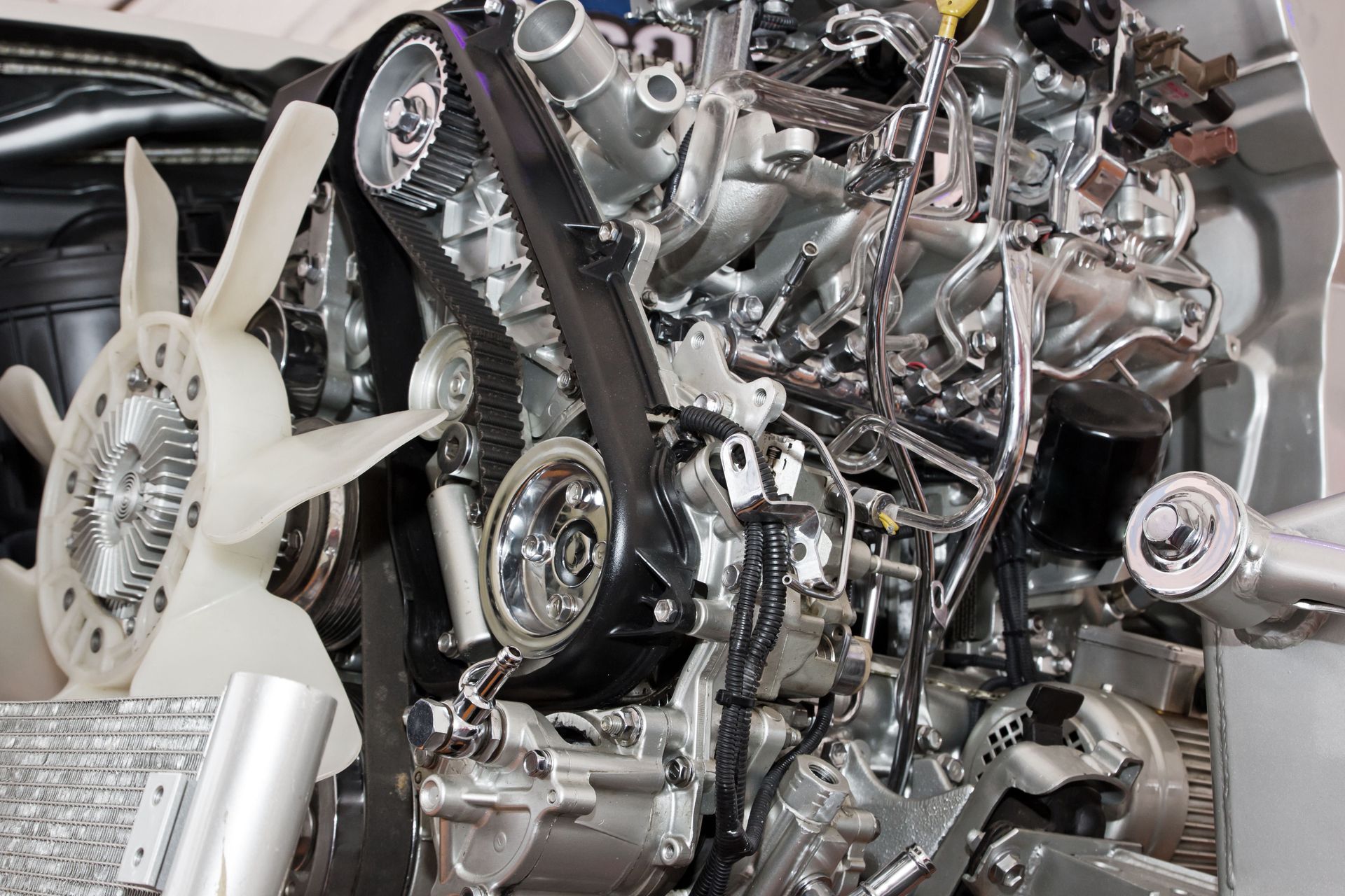 Close-up of a shiny car engine with chrome components and a white cooling fan.