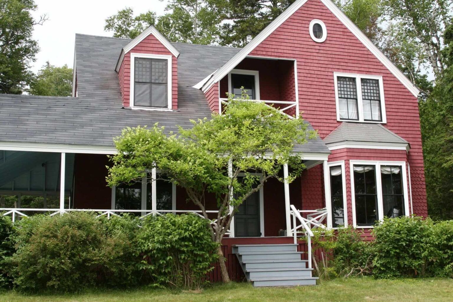 A large red house with a porch and stairs