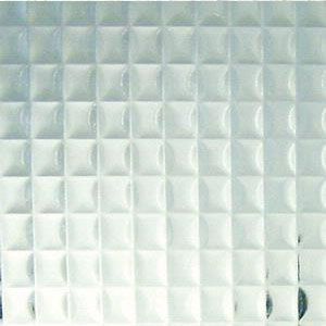 Close-up of a pale green quilted tile surface with a small dark circular object at the lower right.