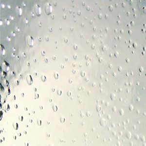 Water droplets on a foggy glass surface with soft gray-white background