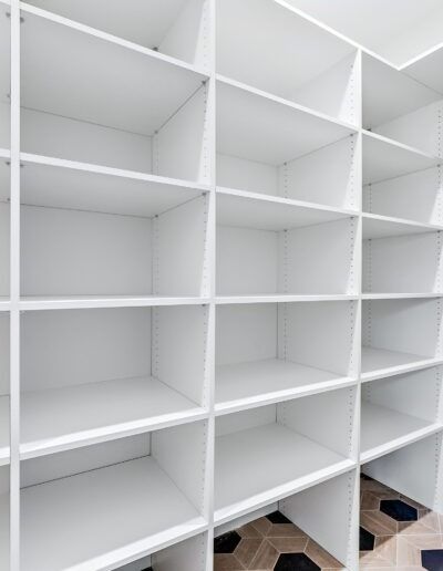 White built-in shelving units with empty cubbies in a bright room.