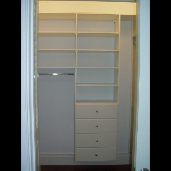 Built-in white closet with shelves and drawers in a doorway alcove