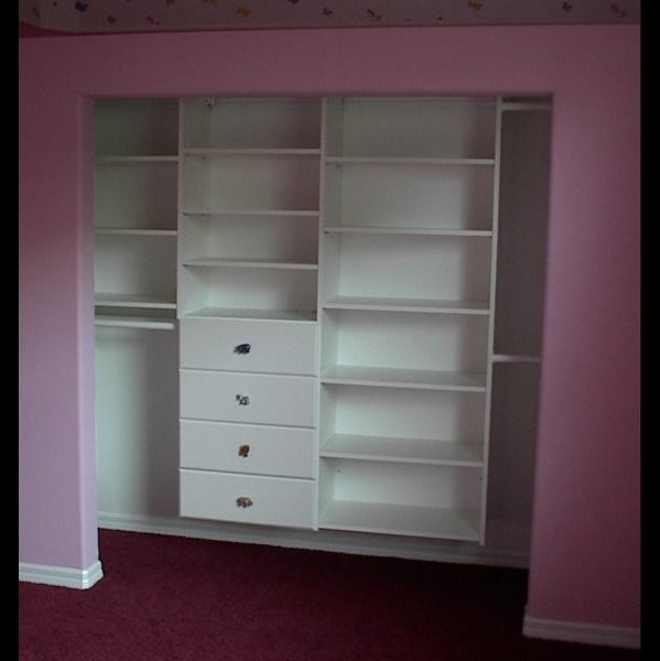 Pink room with a white built-in closet featuring open shelves, drawers, and hanging space