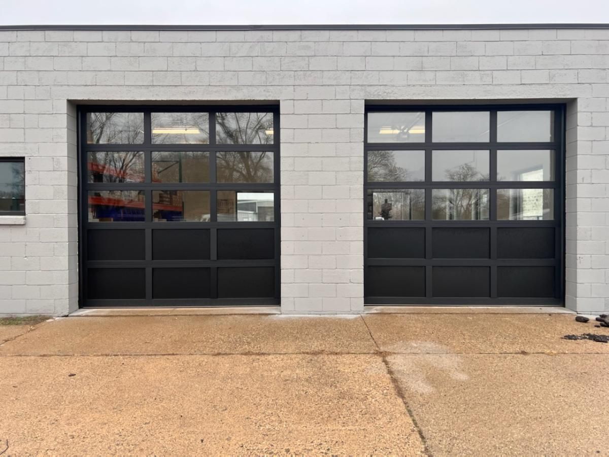 There are two garage doors on the side of a building.
