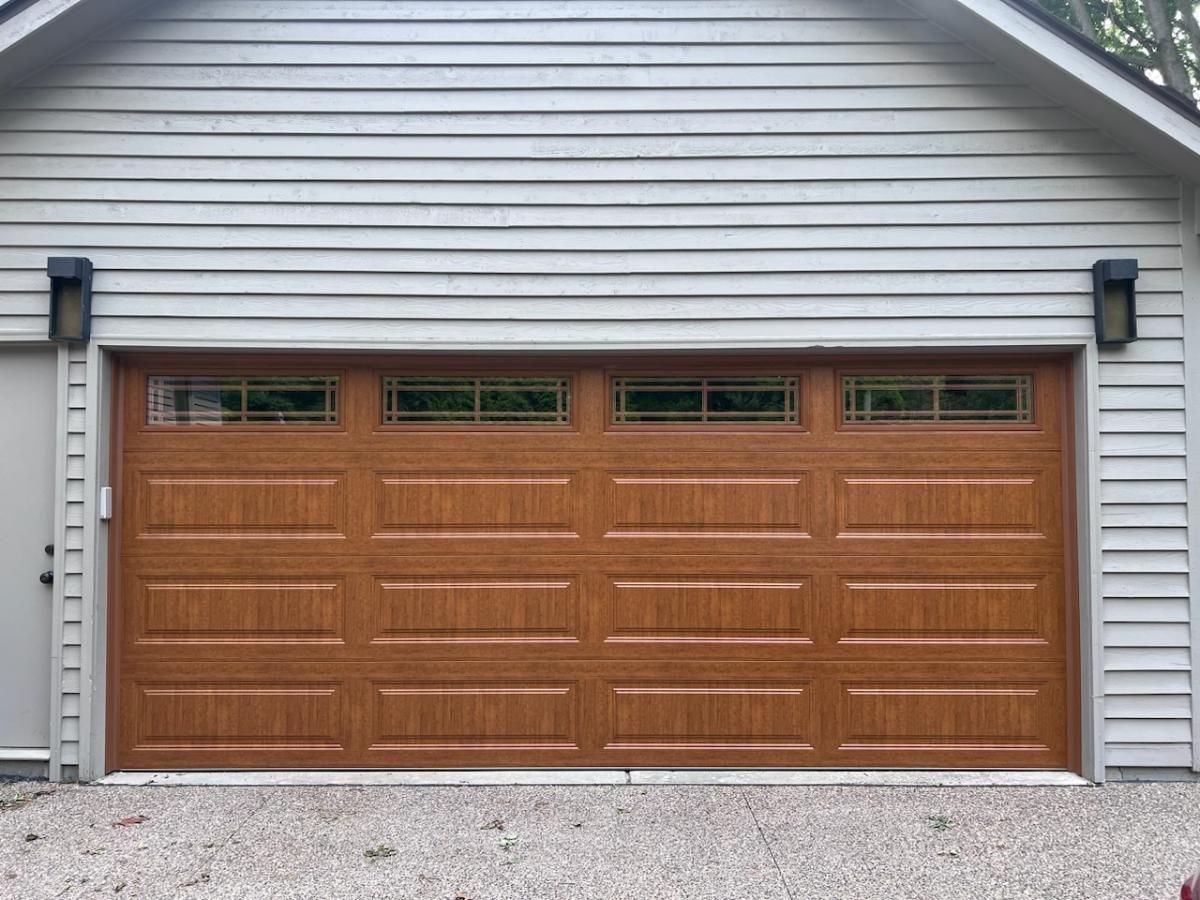 A large wooden garage door is sitting in front of a house.