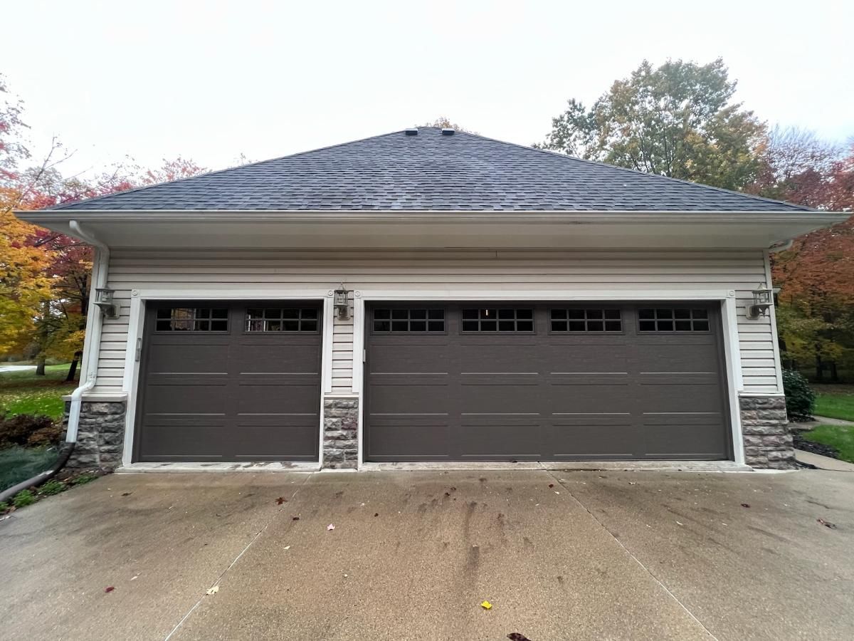 A garage with two garage doors and a roof.