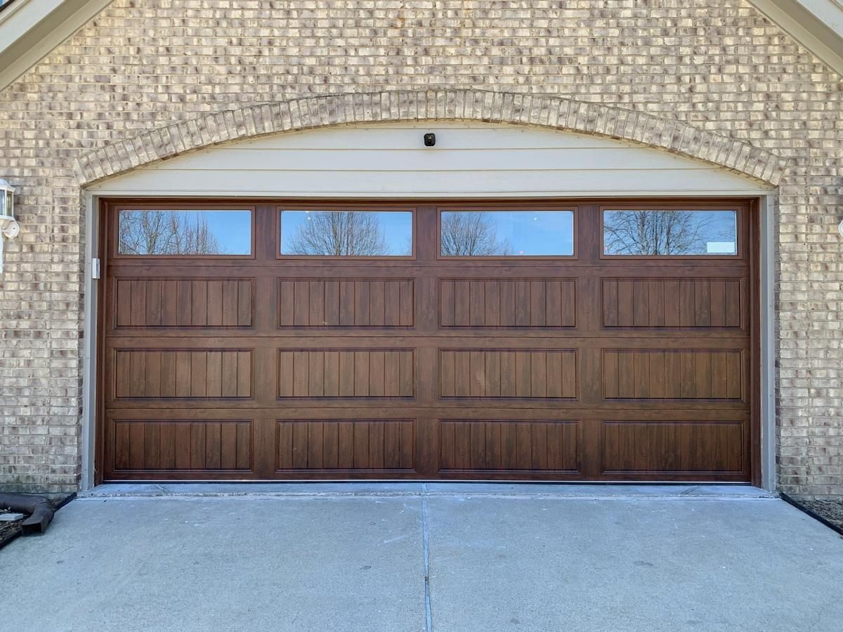 A large wooden garage door on a brick building