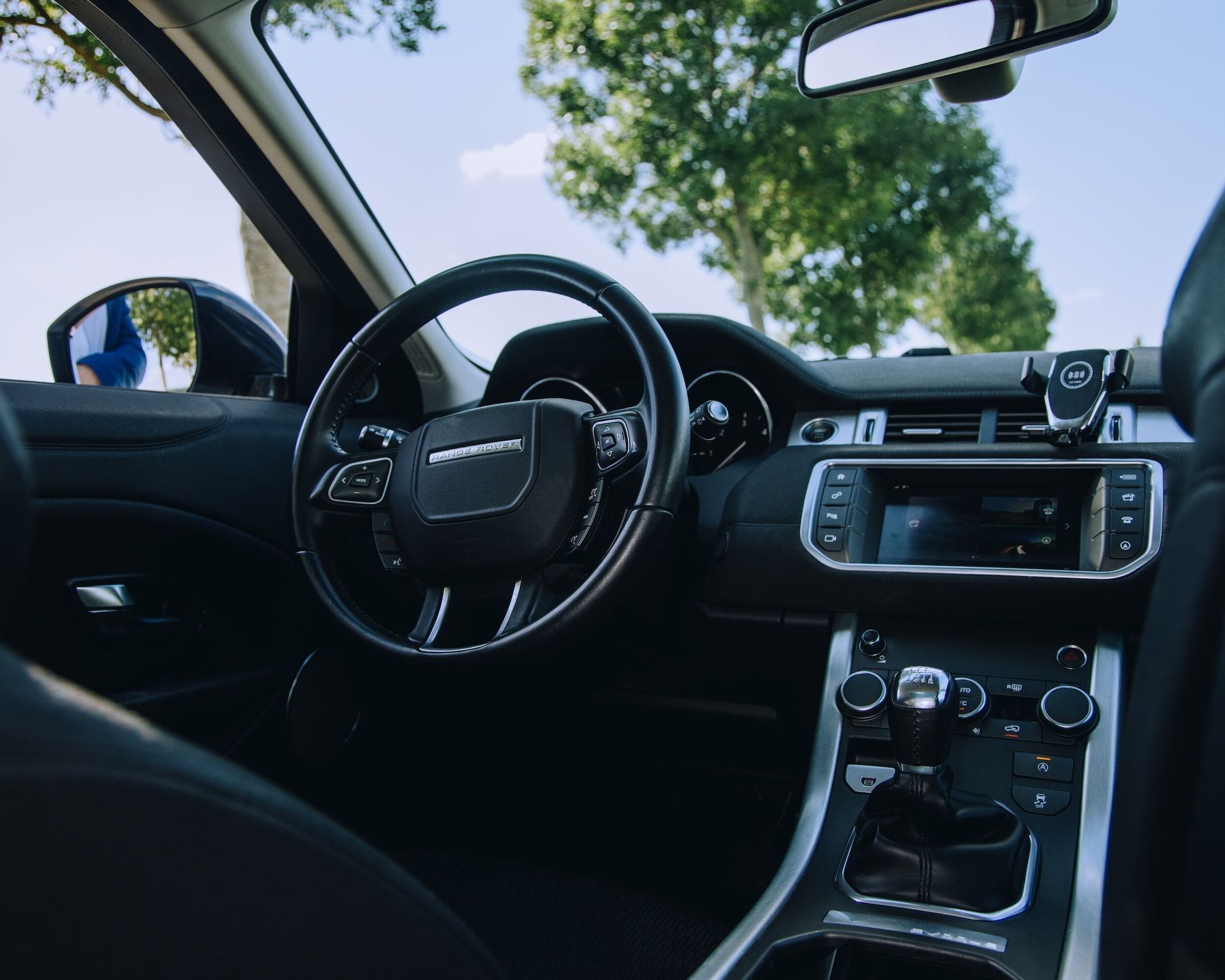 The inside of a car with a steering wheel and dashboard