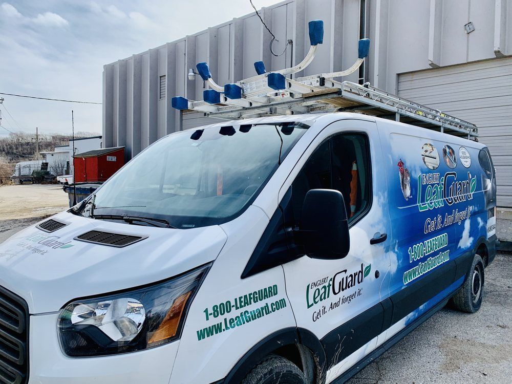 A white van is parked in front of a building.
