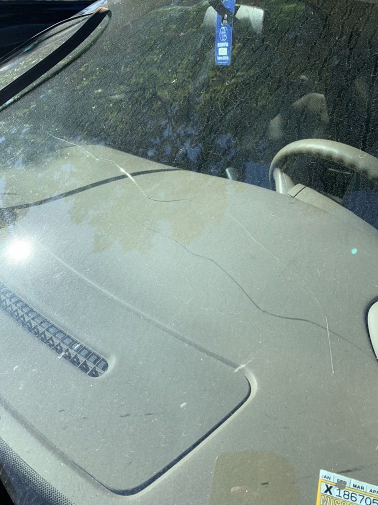 A close up of a car windshield with a sticker on it