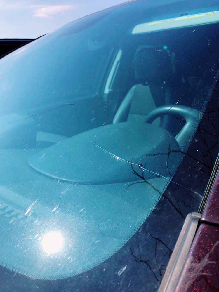 A close up of a car windshield with a cracked windshield