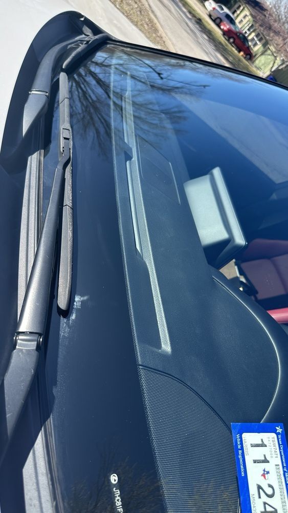 A close up of a car windshield with a license plate that says 11 + 24