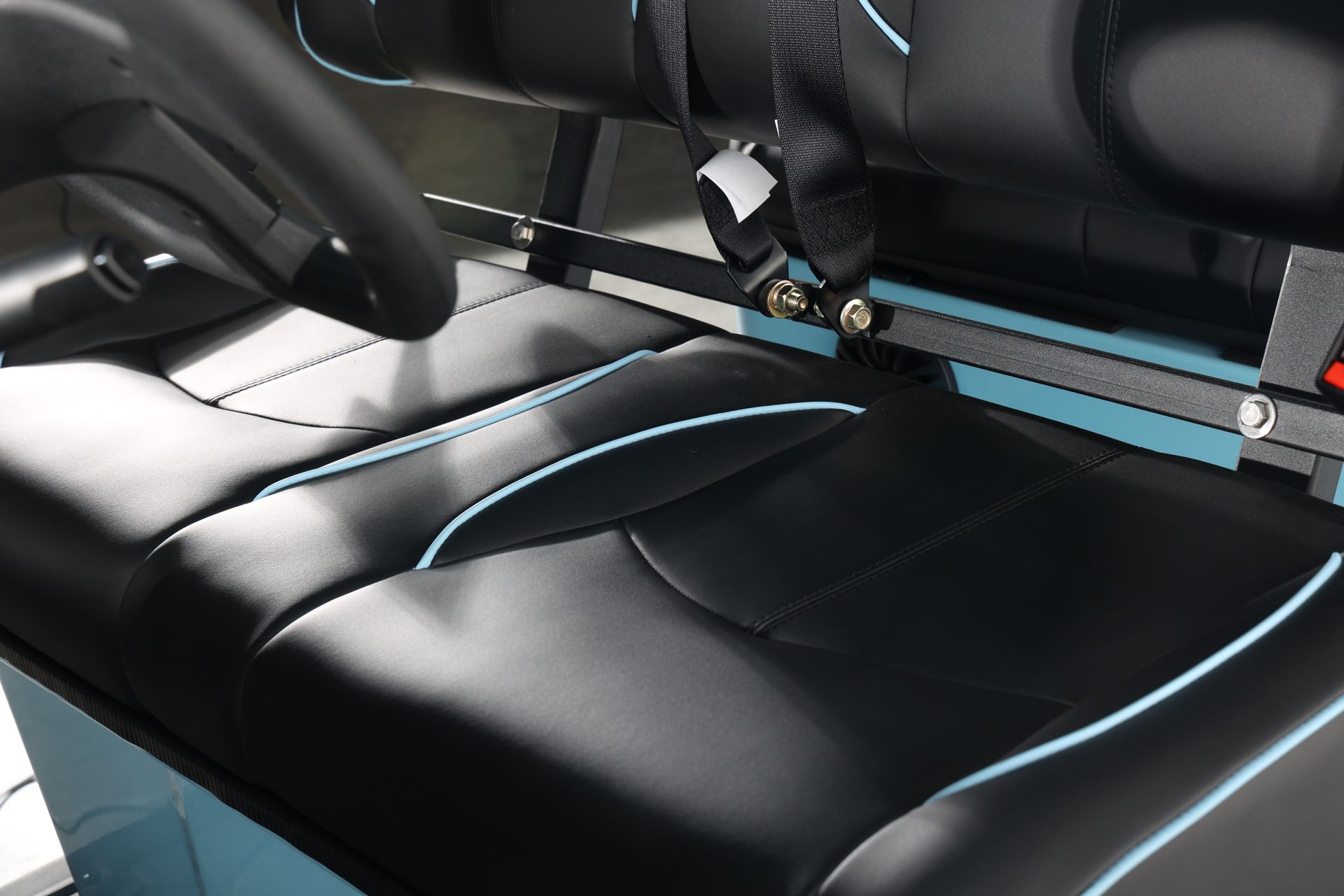 A black and blue golf cart seat with a steering wheel