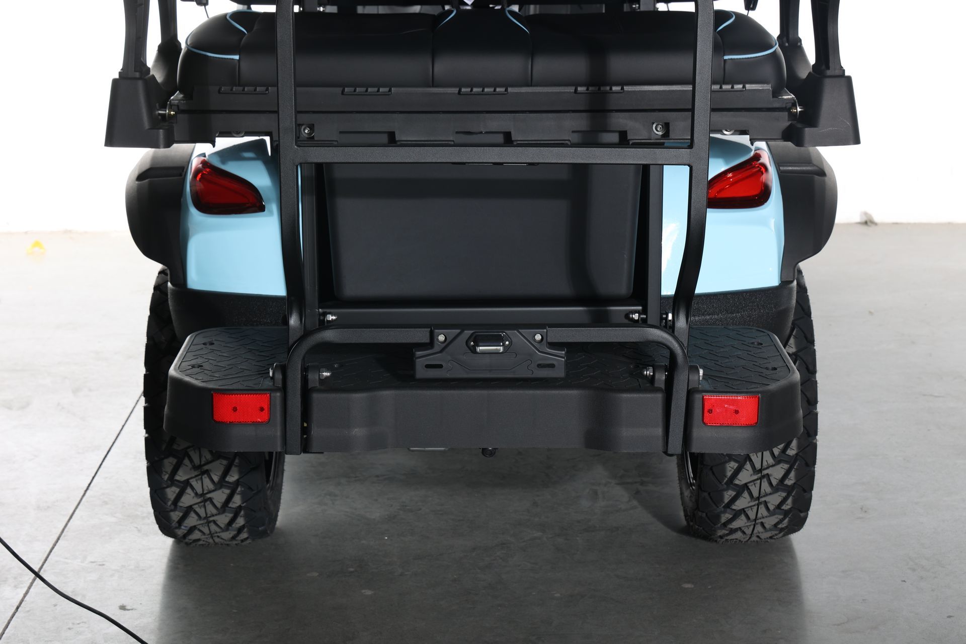 A black and blue golf cart is parked in a garage.