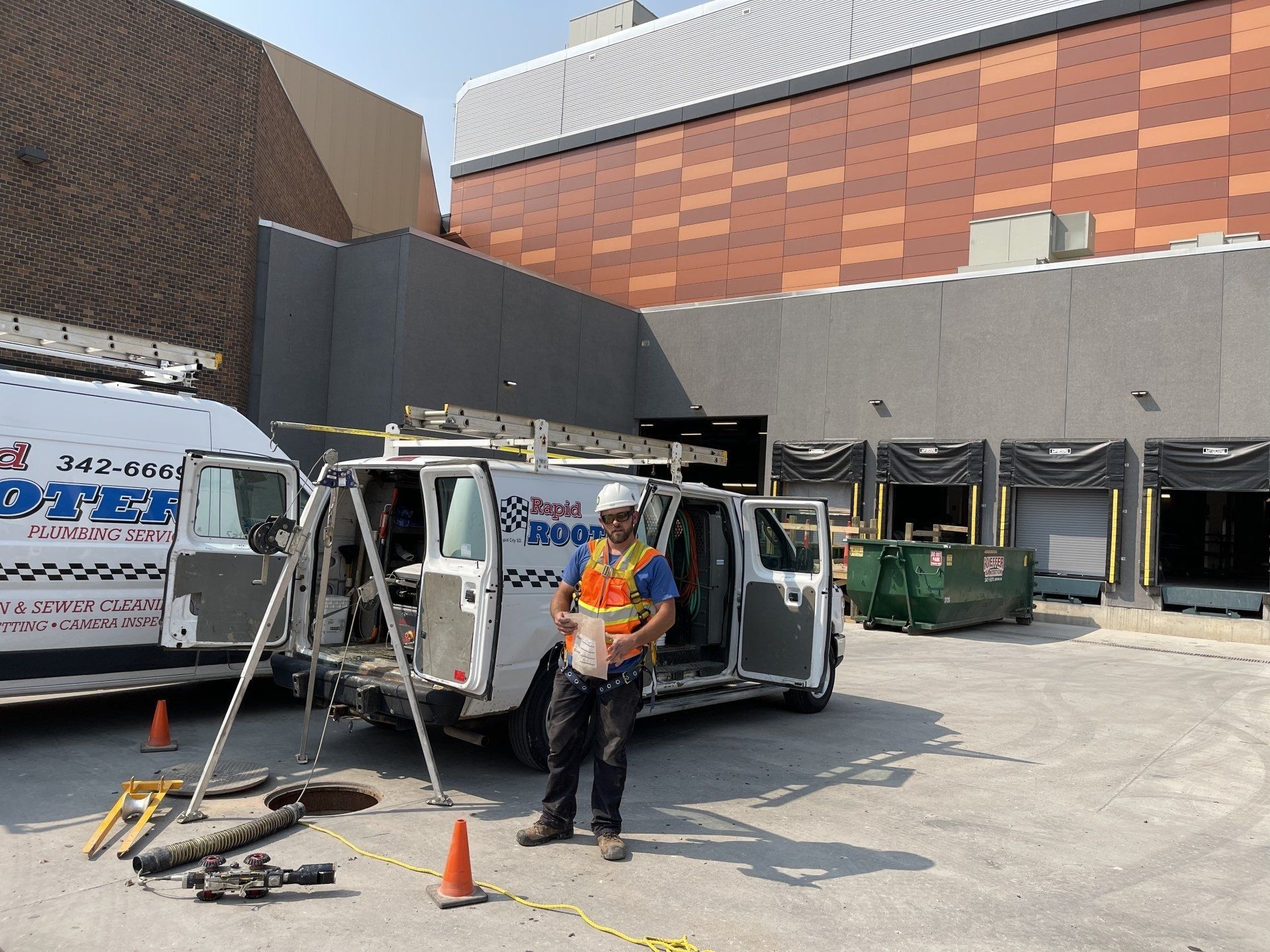 A man is standing in front of a van in a parking lot.