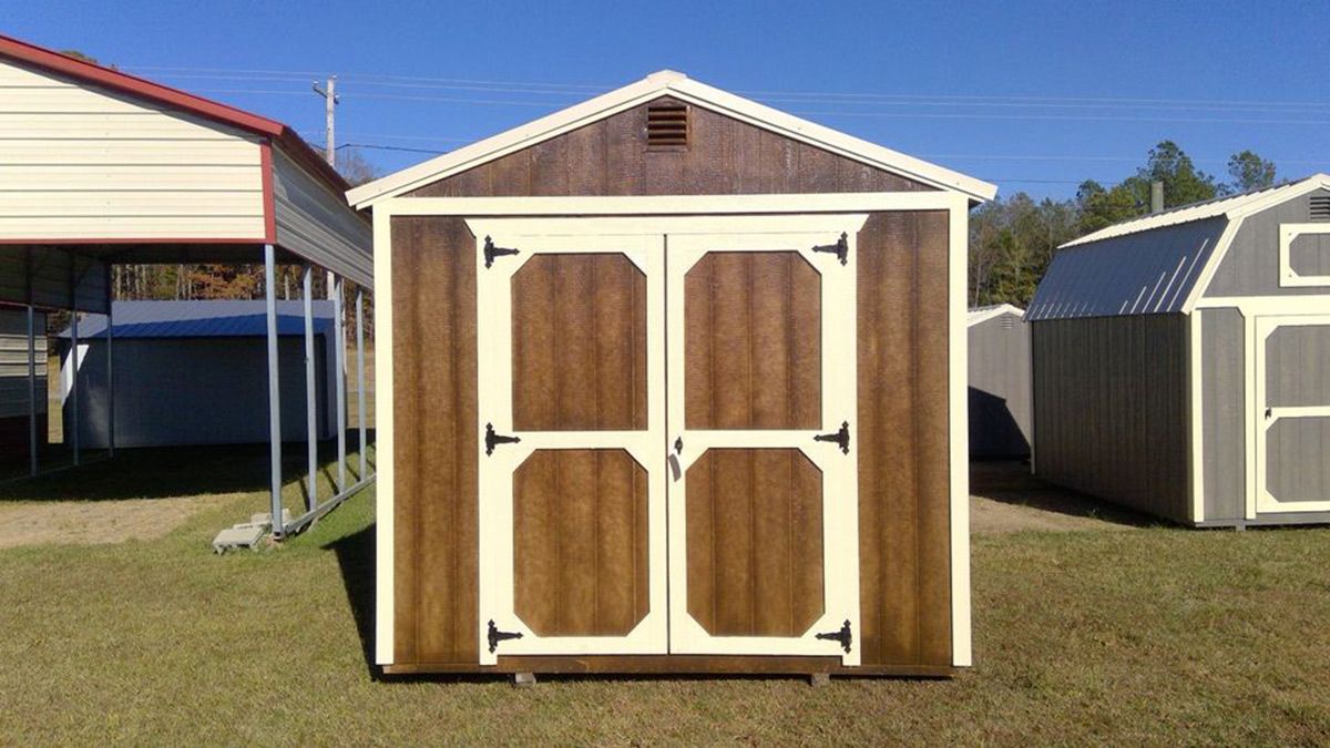 A row of sheds is sitting on top of a lush green field.