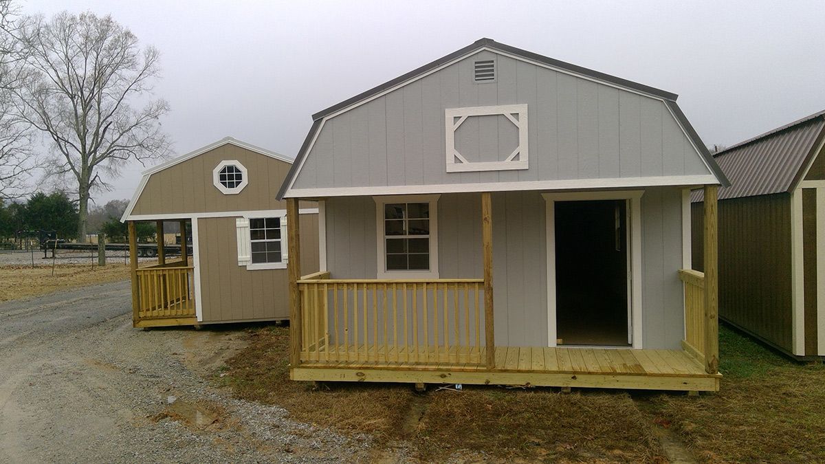 A small house with a porch is sitting next to a large house.