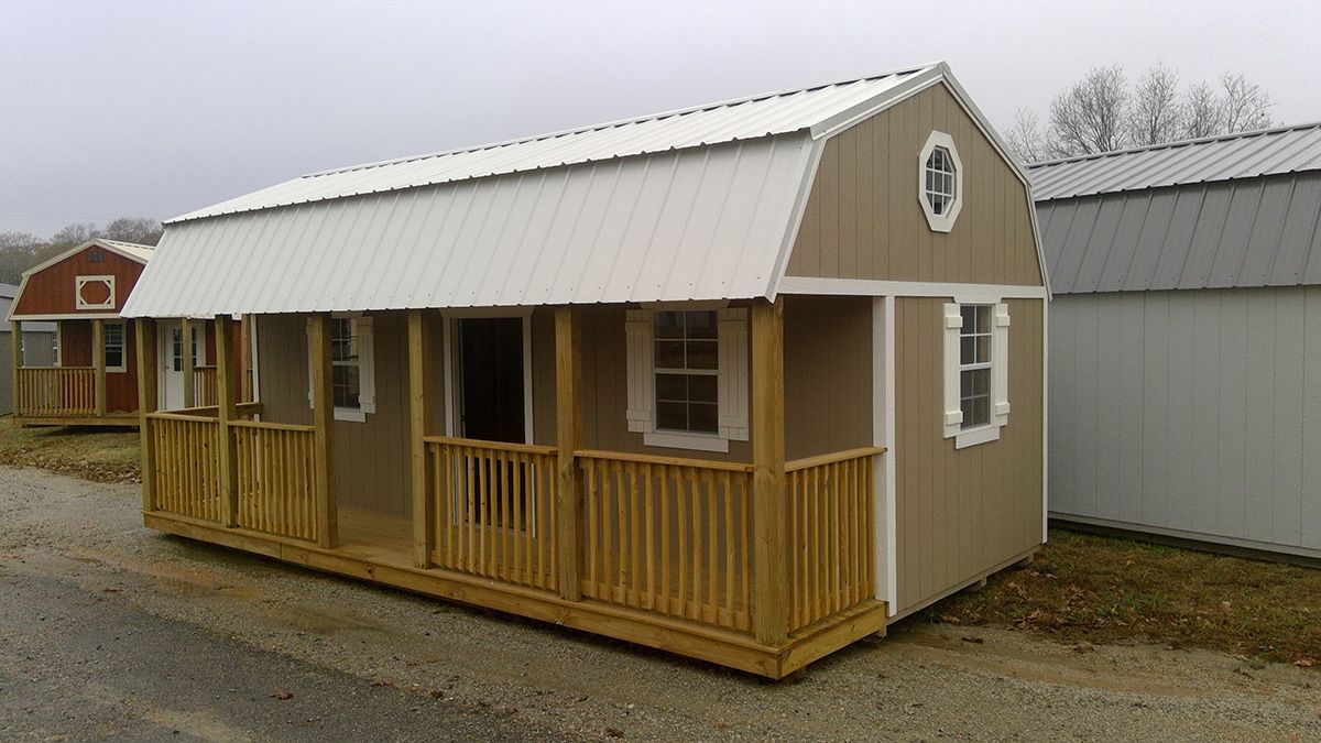 A small house with a porch and a white roof.