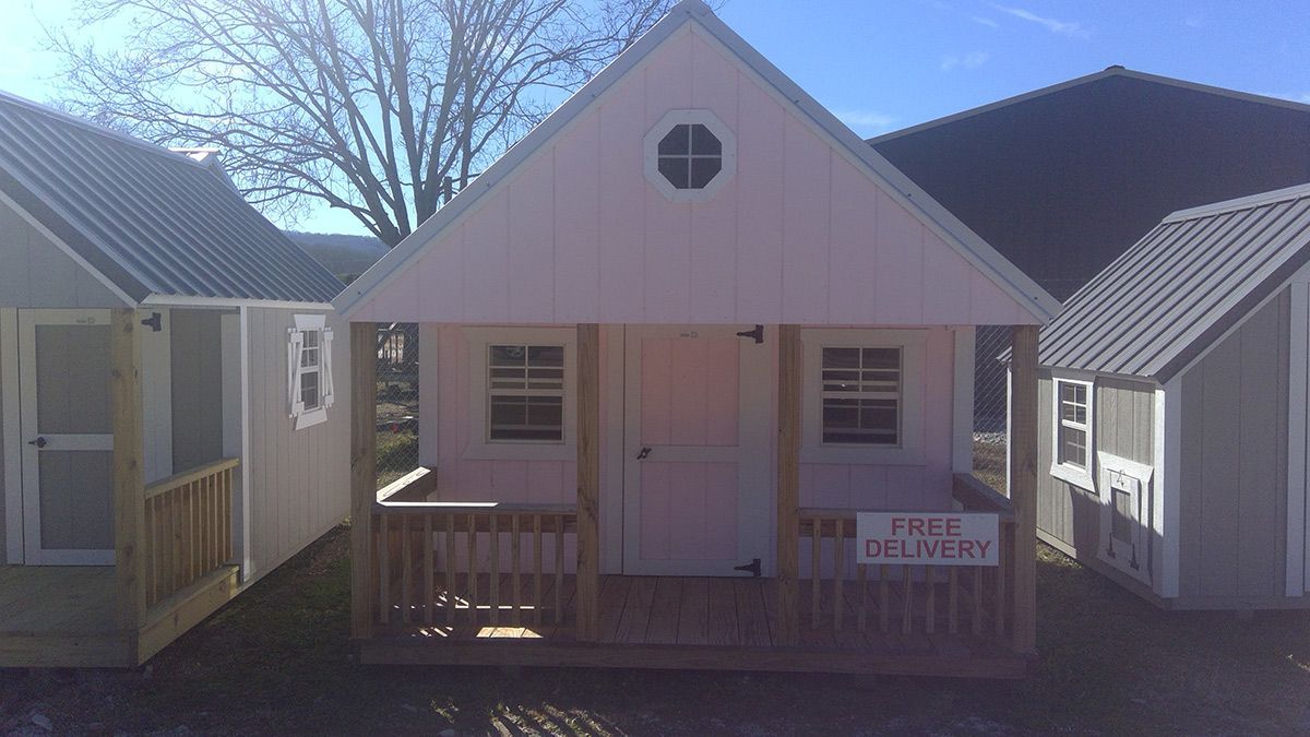 A small white house with a porch and a sign that says free delivery.
