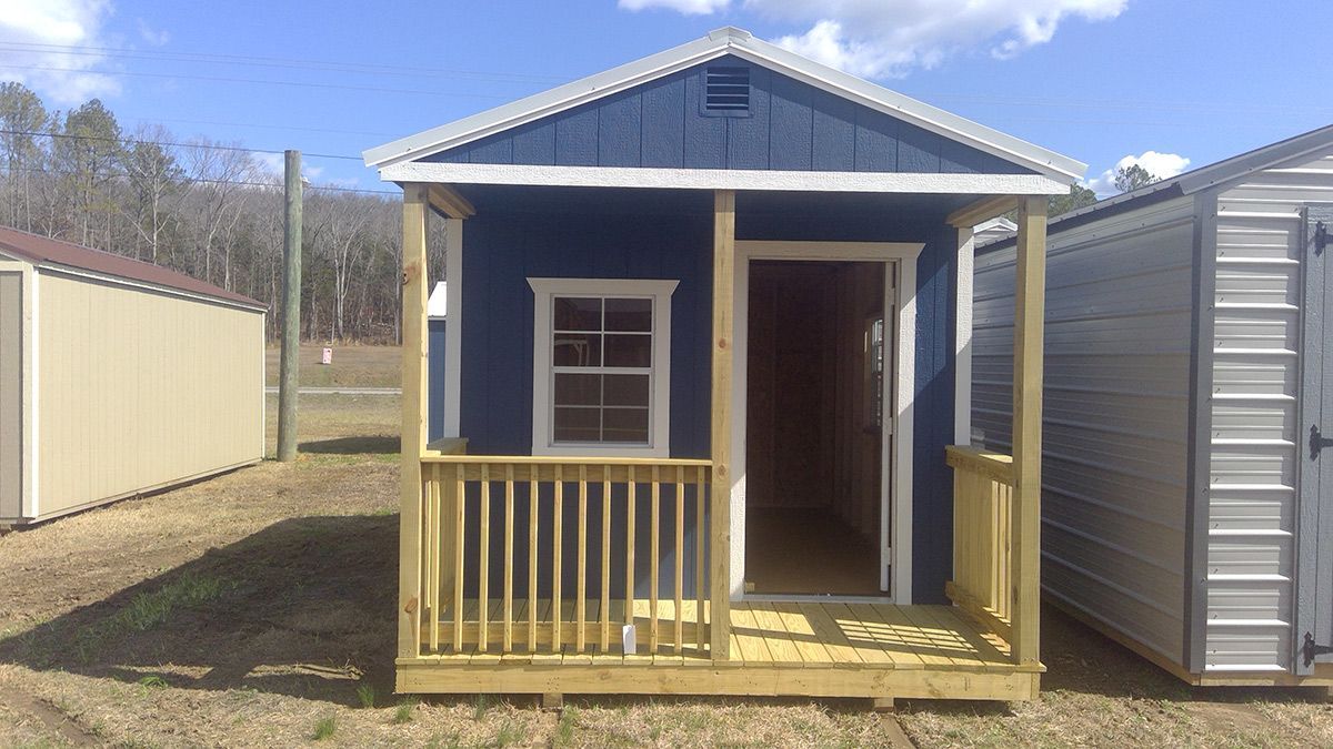 A small blue house with a porch and a window