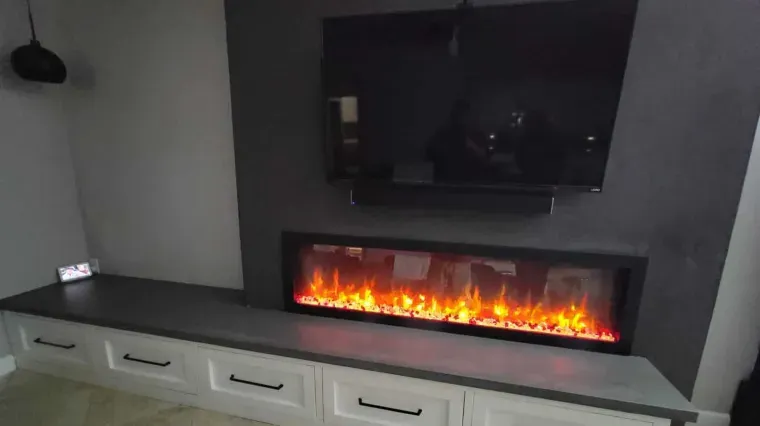 Modern living room with wall-mounted TV above an electric fireplace and white storage cabinets below