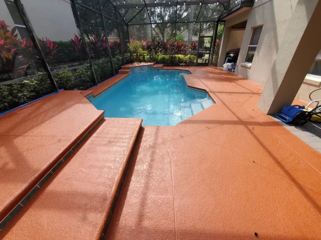 Screened backyard patio with a blue swimming pool and terracotta tile decking