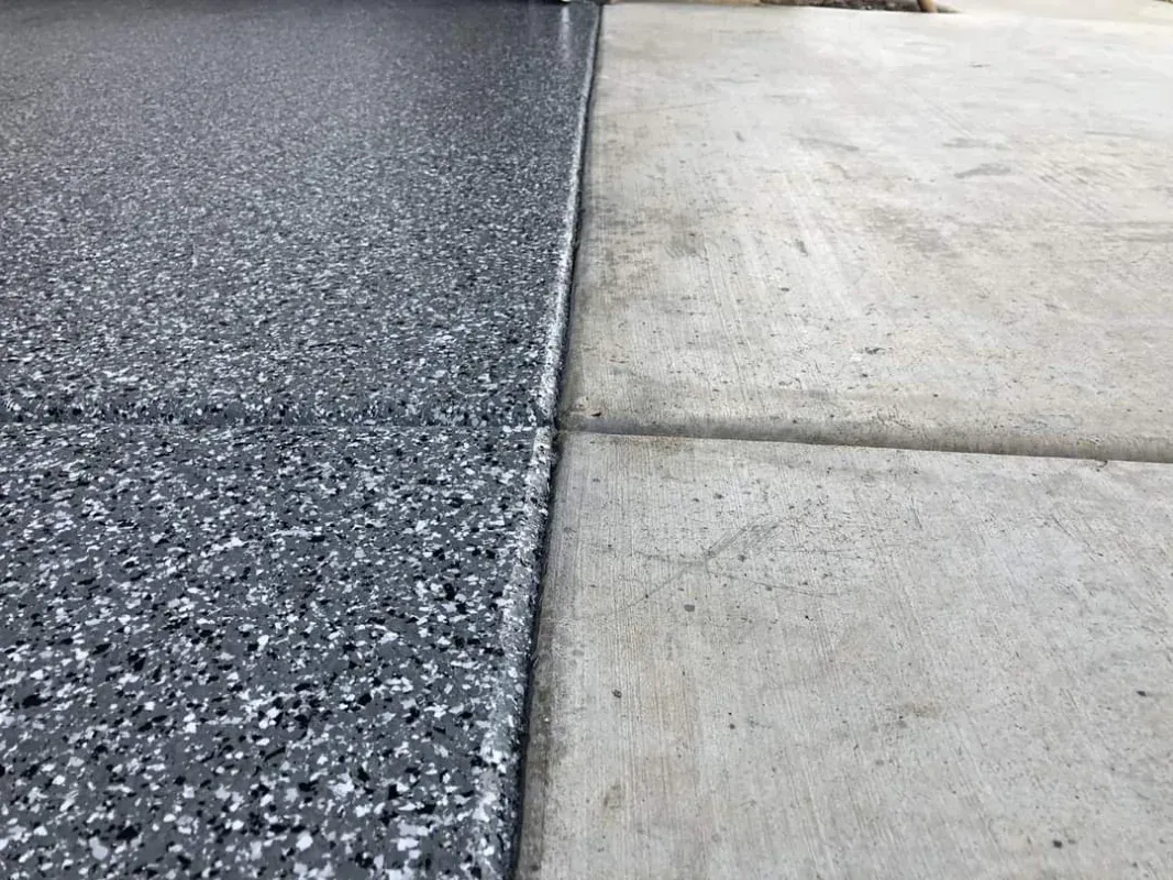 Split driveway surface: dark asphalt on the left, light concrete on the right.