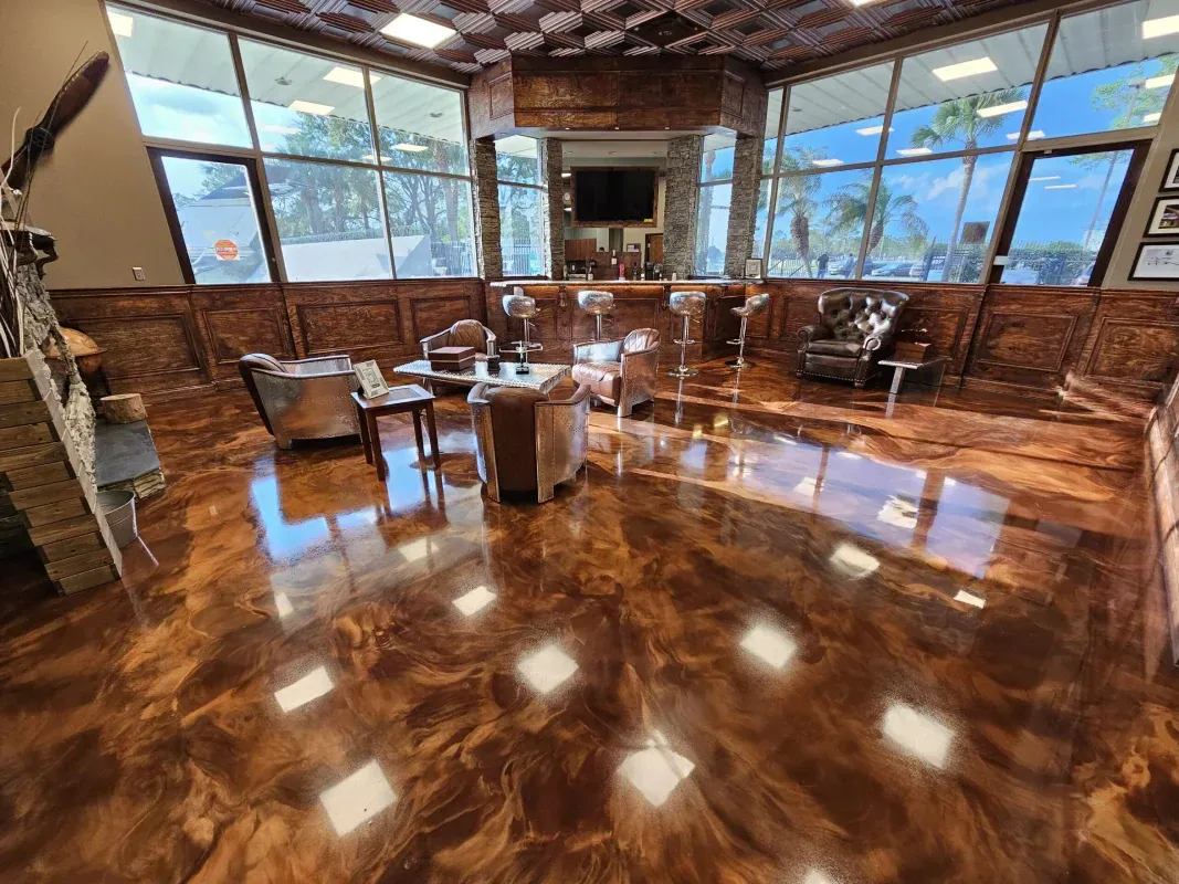Bright lounge with polished wooden floors, wicker chairs, and large windows overlooking palm trees